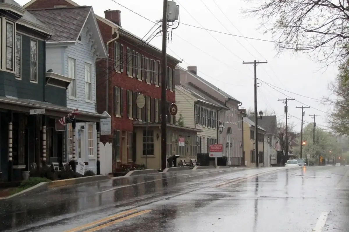 Historic main street lined with brick and clapboard buildings on a rainy day