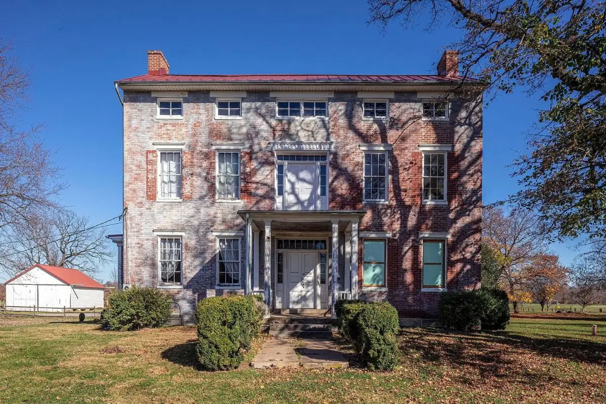 Two-story brick farmhouse with a columned entry porch