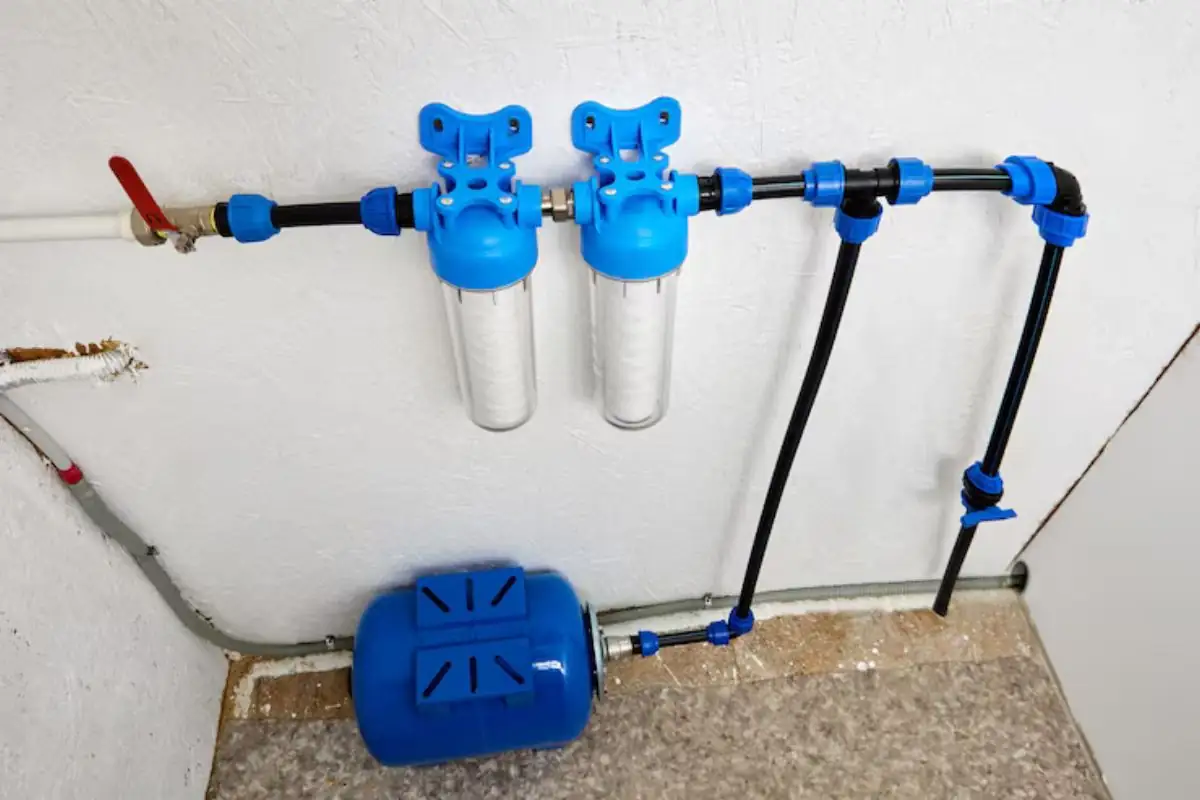 Two blue filter housings and a pressure tank on a home water line